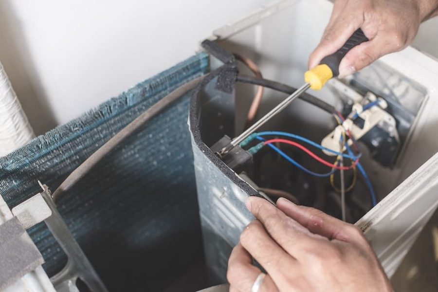 technician's hand fixing a home comfort system