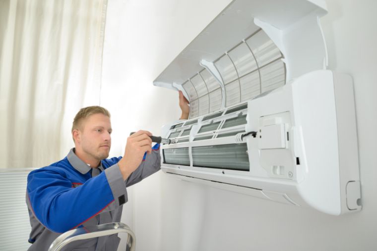 air-conditioner-wall-unit-760×507 HVAC tech working on ac unit.