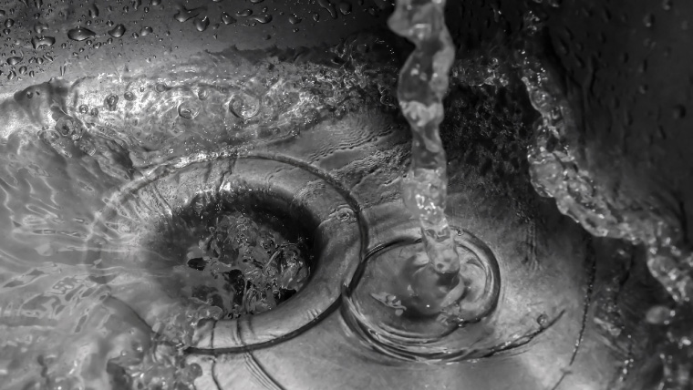 sink drain with water pouring down Call Alco Air today at for all your bathroom plumbing needs.