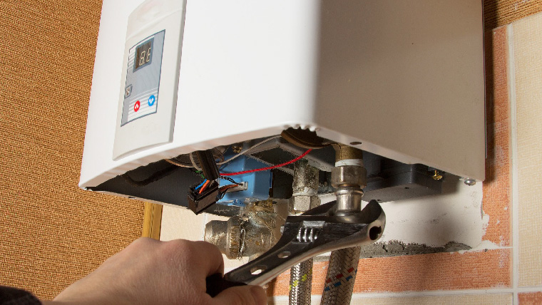hands holding wrench fixing unit Call Alco Air today at (903) 212-7708 for professional water heater installation services.